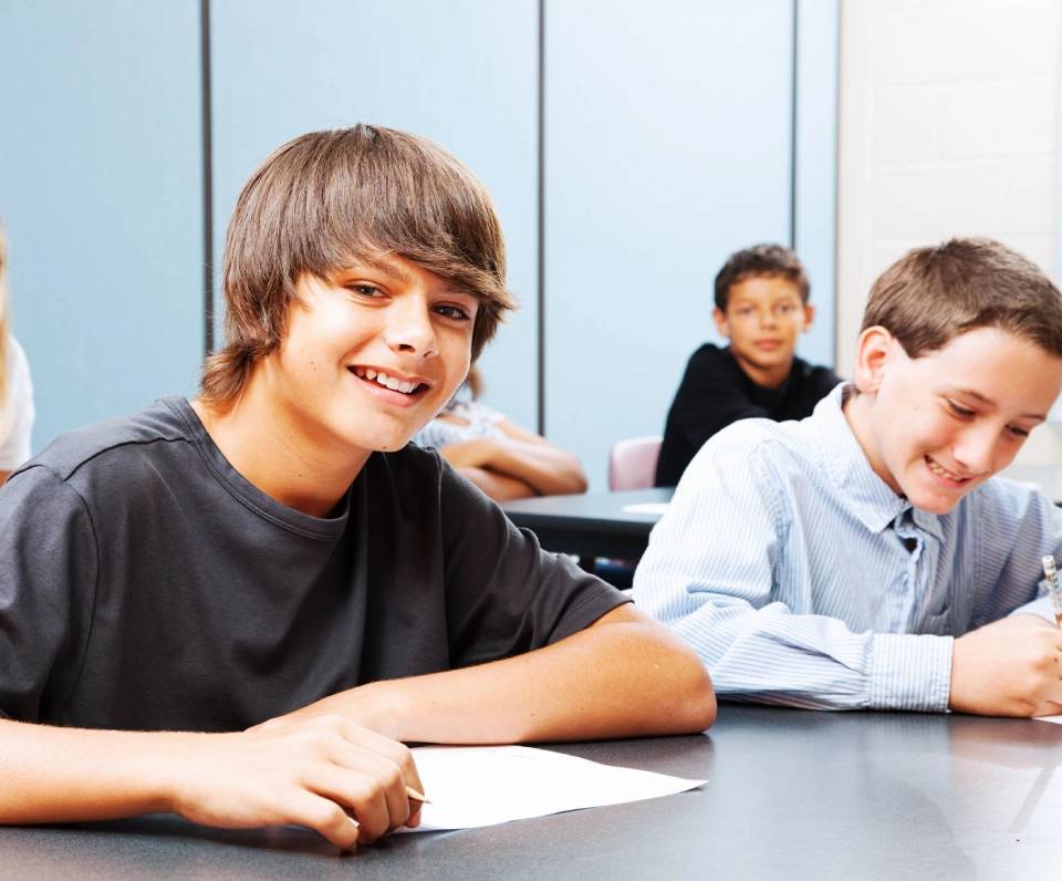 A group of young people sitting at a table.