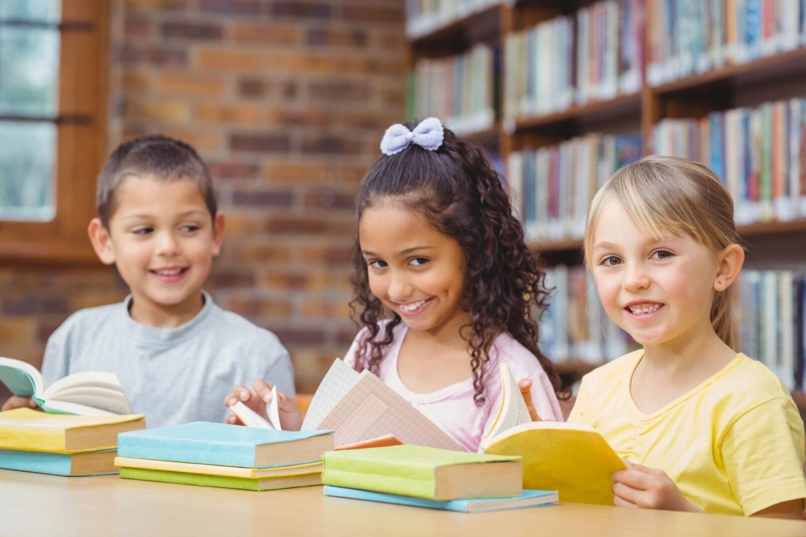 A group of children sitting at a table with books.